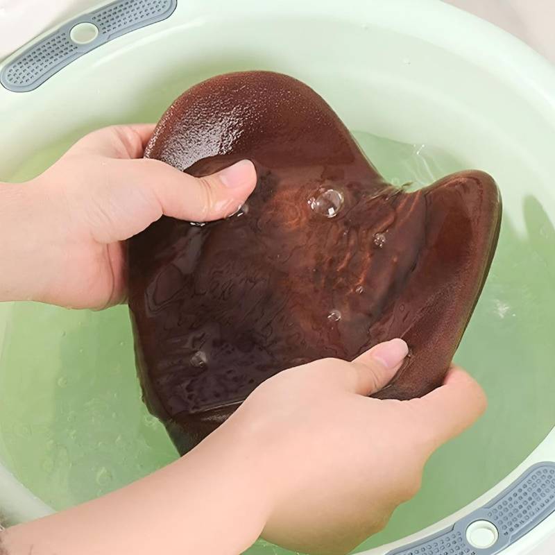 Gant de lotion autobronzant brun utilisé pour appliquer de la lotion dans un bain.