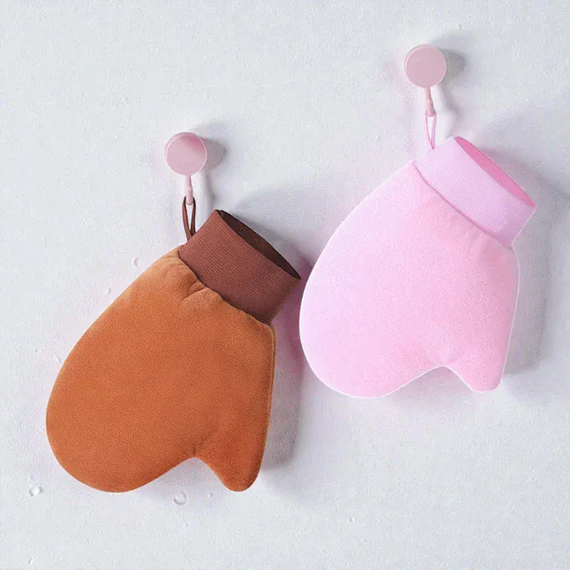 Gant de lotion autobronzant brun et rose suspendu à des crochets.