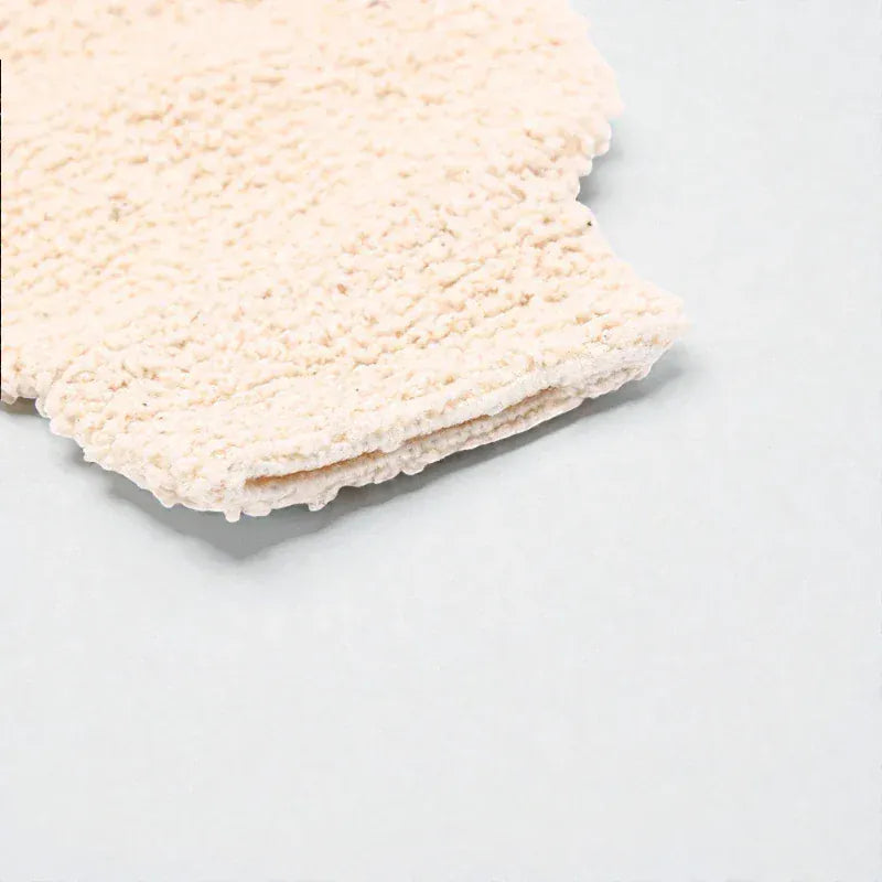 Gant de toilette texturé en fibre de bambou de couleur crème.