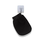 Gant de toilette noir double face suspendu à un crochet.