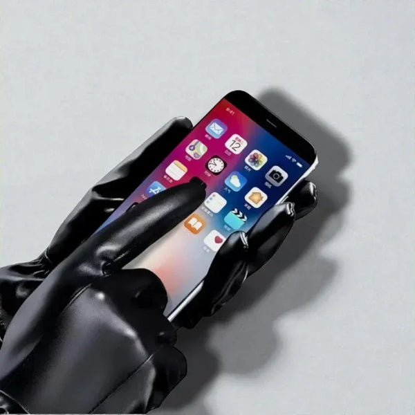 Gants en cuir noir avec doublure en laine tenant un téléphone.