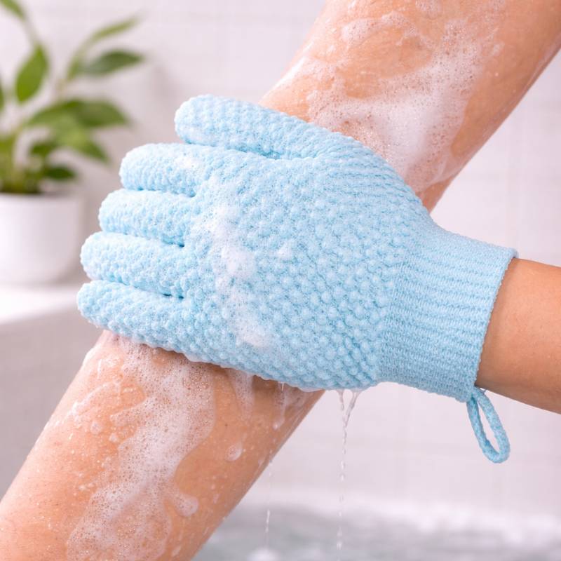 Un gant de bain bleu à cinq doigts avec de la mousse sur un bras.