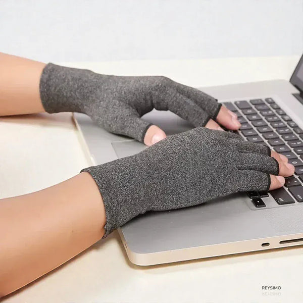 Gants de compression unisexes gris sans doigts sur un clavier d'ordinateur.