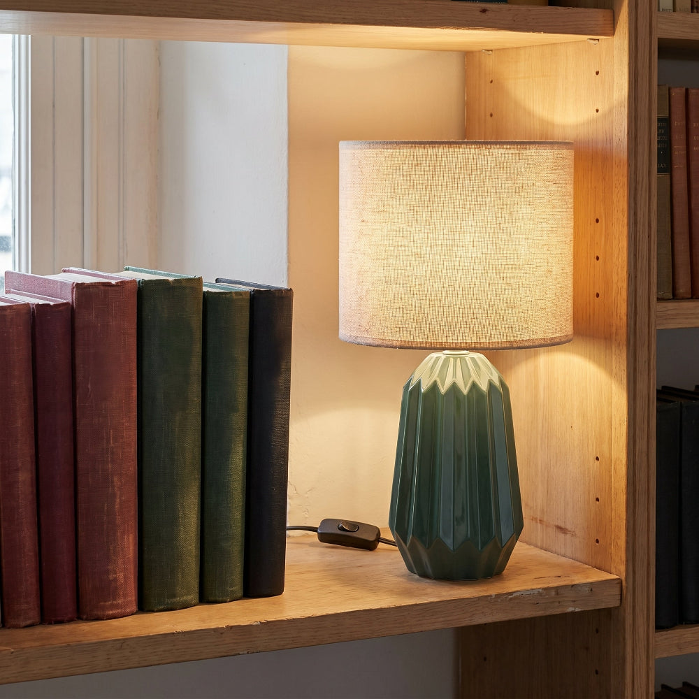 Lampe céramique pied plissé sur étagère avec les livres