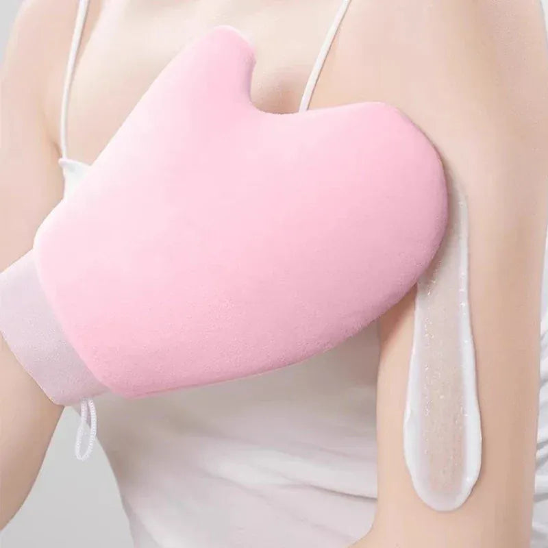 Gant de lotion pour le corps autobronzant rose sur un bras avec de la crème.